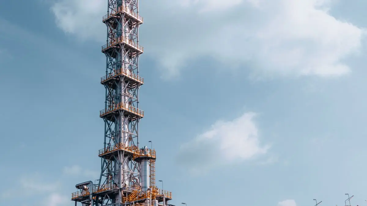 Oil refinery tower against a blue sky
